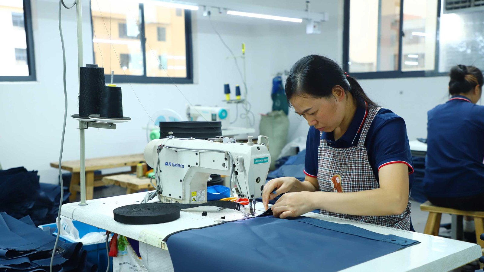 Sewing outdoor chair fabric at a production partner facility
